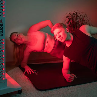 Person foran Soma Red Light panel under rødlysterapi – LED-lys med rødt og infrarødt lys for hud, muskler og energi.